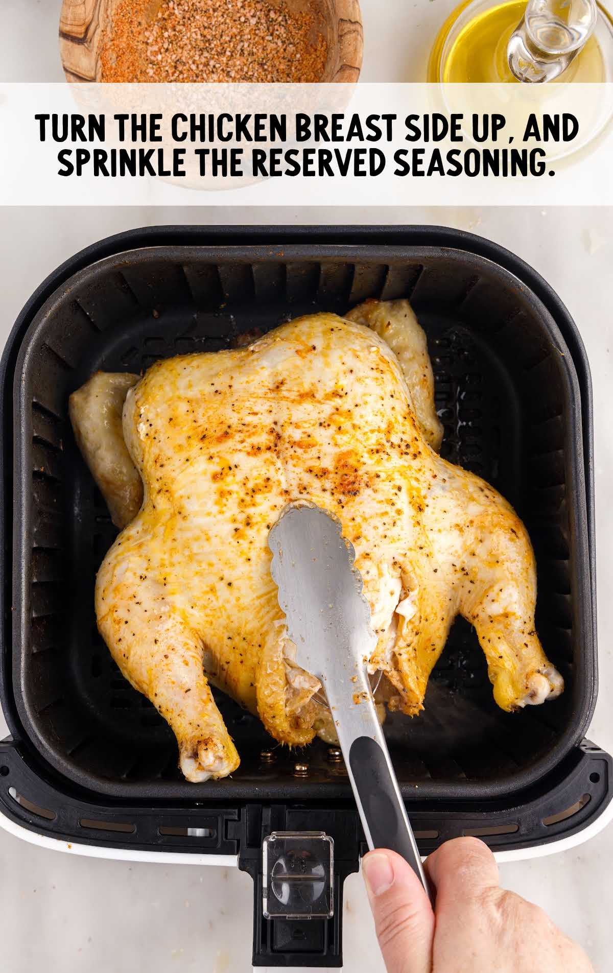 seasoning sprinkled on the whole chicken in an air fryer
