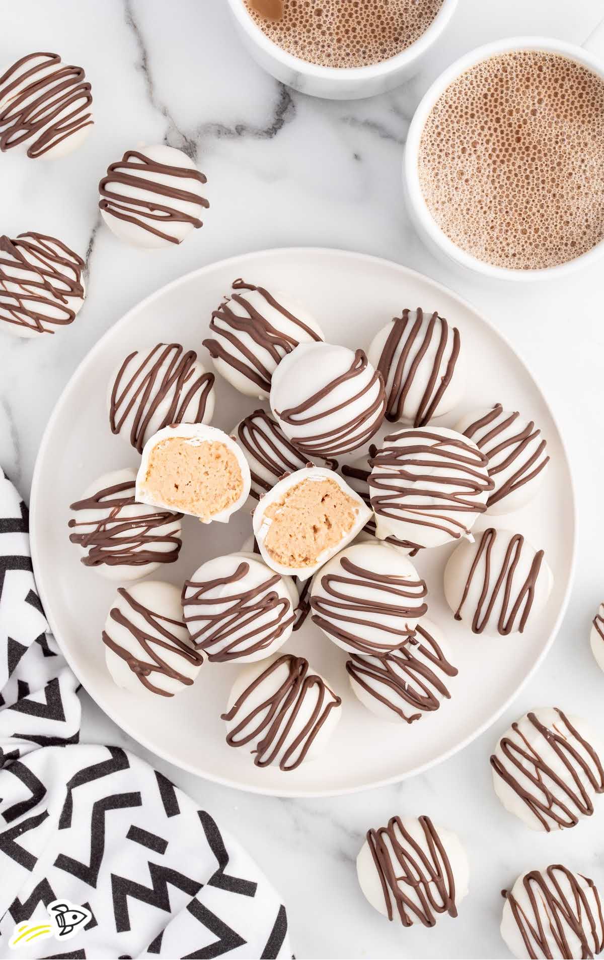 overhead shot of Baileys Cheesecake Balls piled on top of each other on a plate with one split in half