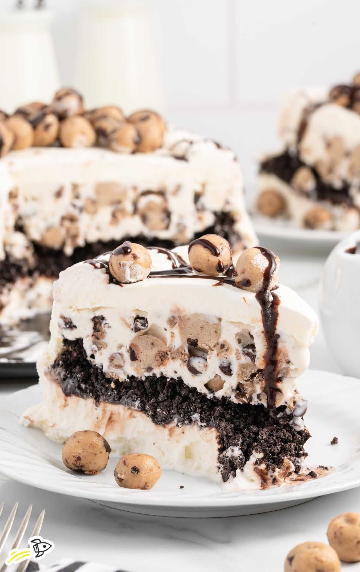 a close-up shot of a slice of Cookie Dough Ice Cream Cake on a plate
