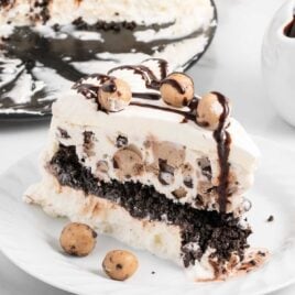 a close up shot of a slice of Cookie Dough Ice Cream Cake on a plate