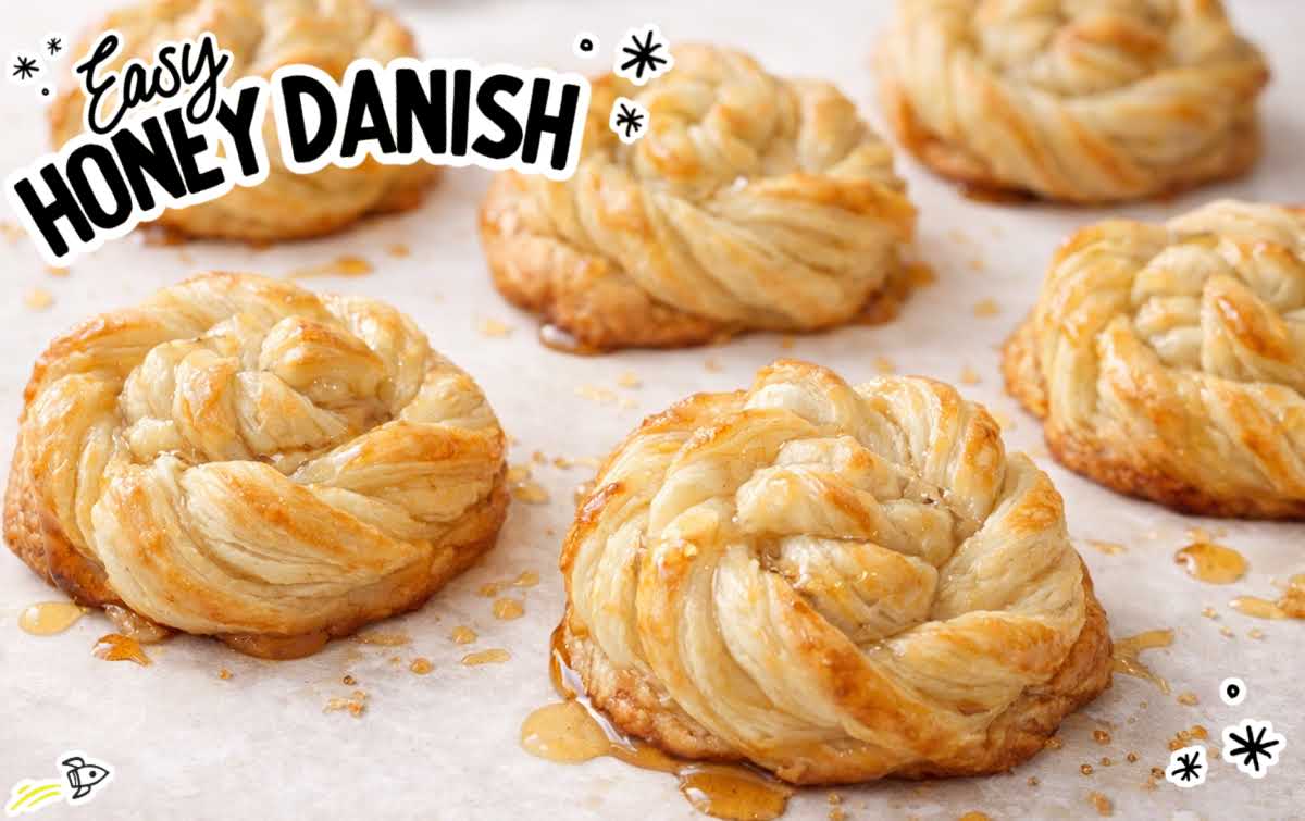 Golden honey danish made with puff pastry, flaky layers visible and drizzled with honey