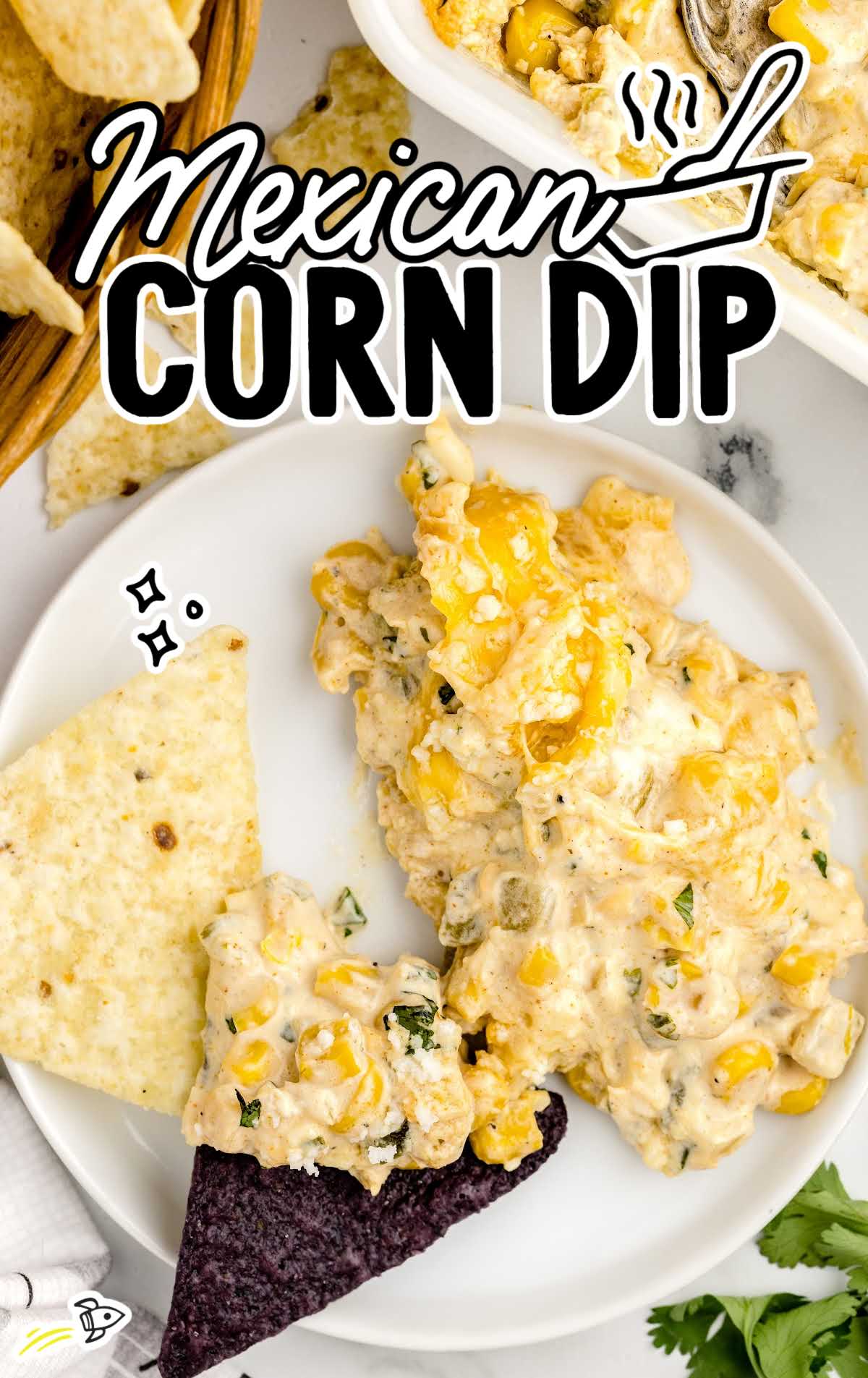 overhead shot of Mexican Corn Dip garnished with parsley and served with tortilla chips on a plate