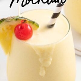 close up of a glass of Pina Colada Mocktail garnished with a slice of pineapple and a cherry