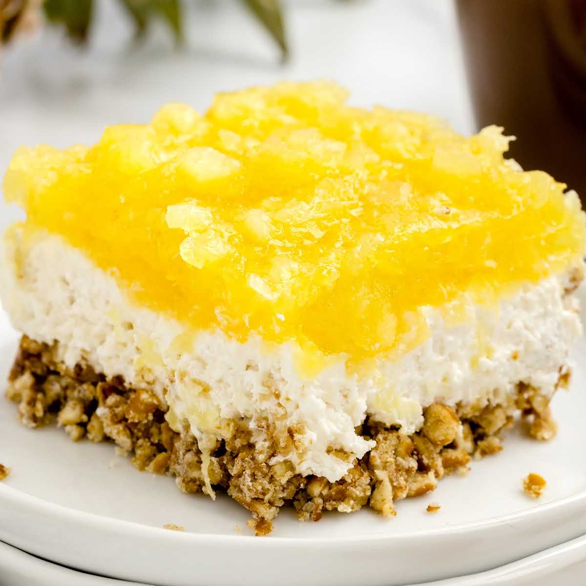a close-up shot of a slice of Pineapple Pretzel Salad on a plate
