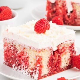 a slice of raspberry poke cake on a plate