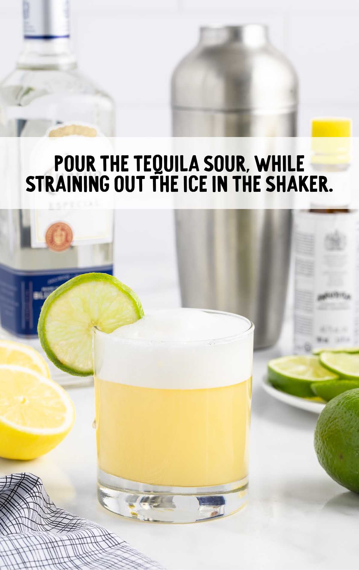 Tequila Sour poured into a glass and garnished with a slice of lime