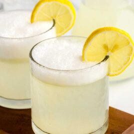 close up shot of glasses of vodka sour garnished with a lemon