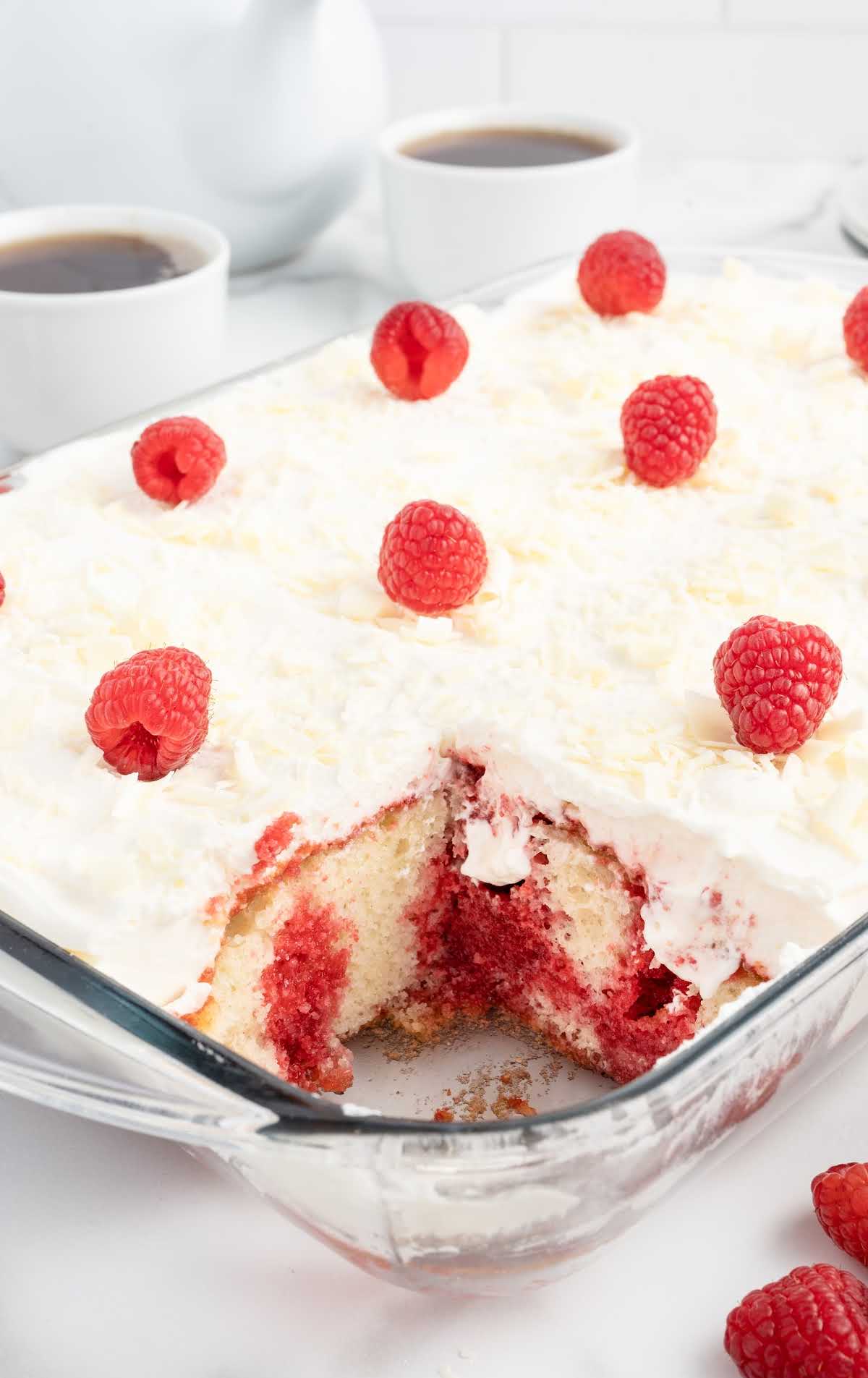 cake topped with raspberries in a baking dish