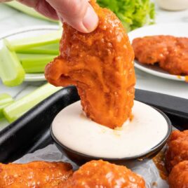 a close up shot of a Buffalo Chicken Tenders dipped into ranch