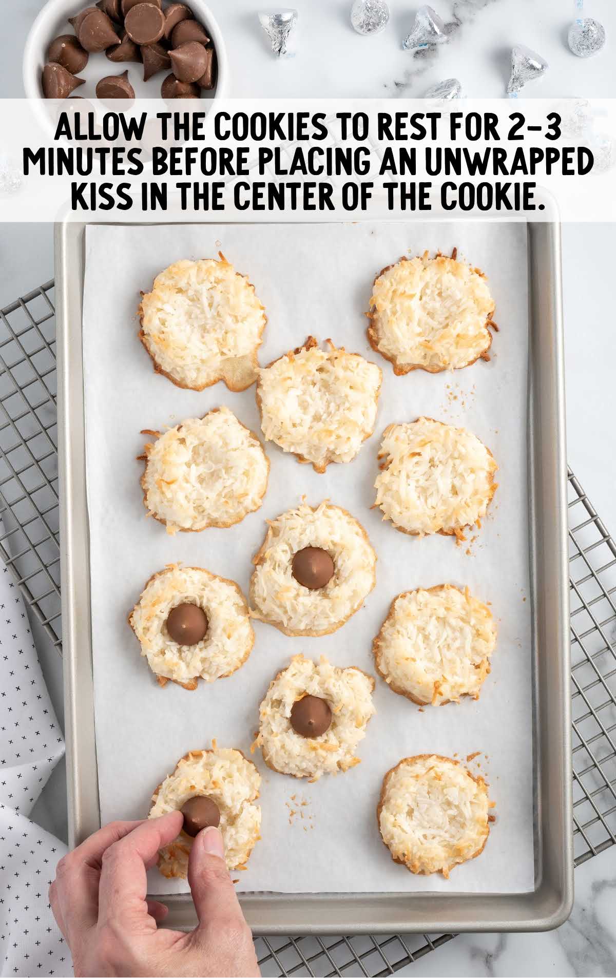 Hershey kisses placed on top of the cookies on a baking sheet