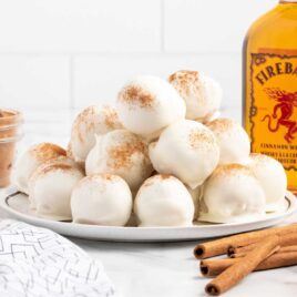 a close up shot of Fireball Whisky Balls piled on top of each other on a plate