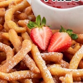 close up shot of Funnel Cake Fries with a sliced strawberry