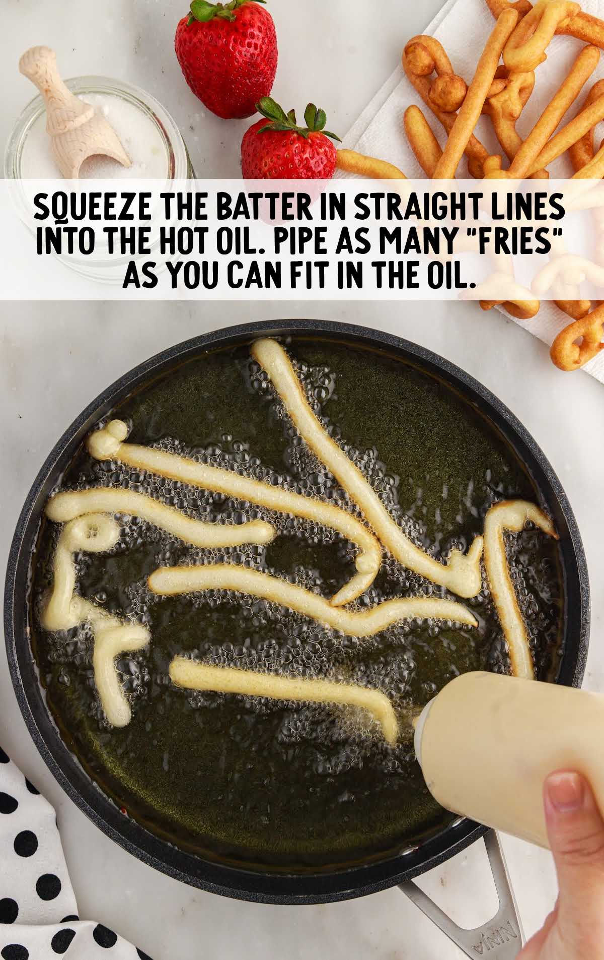 batter squeezed in straight line in a the oil