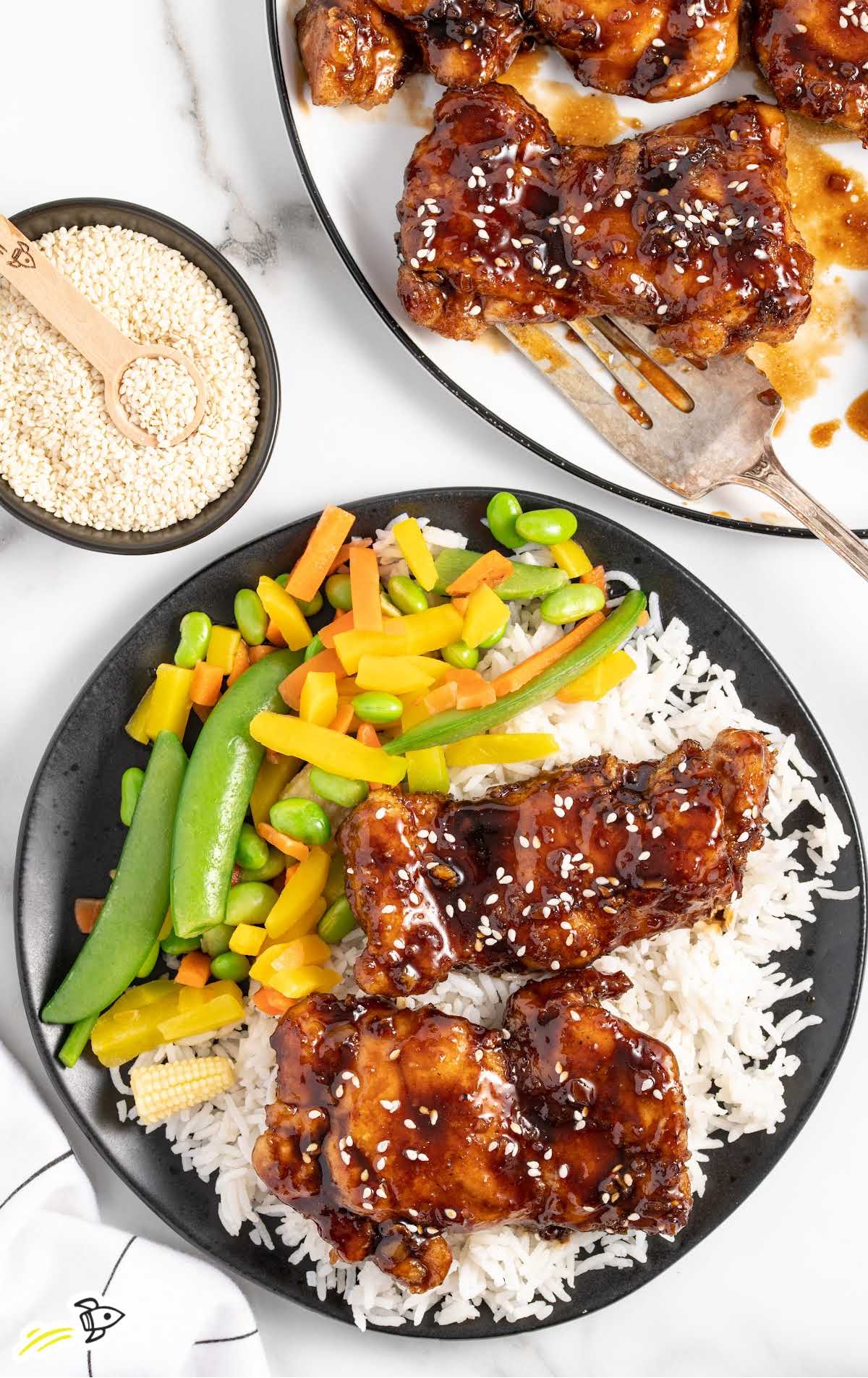 overhead shot of a plate of honey glazed chicken served with white rice and vegetables