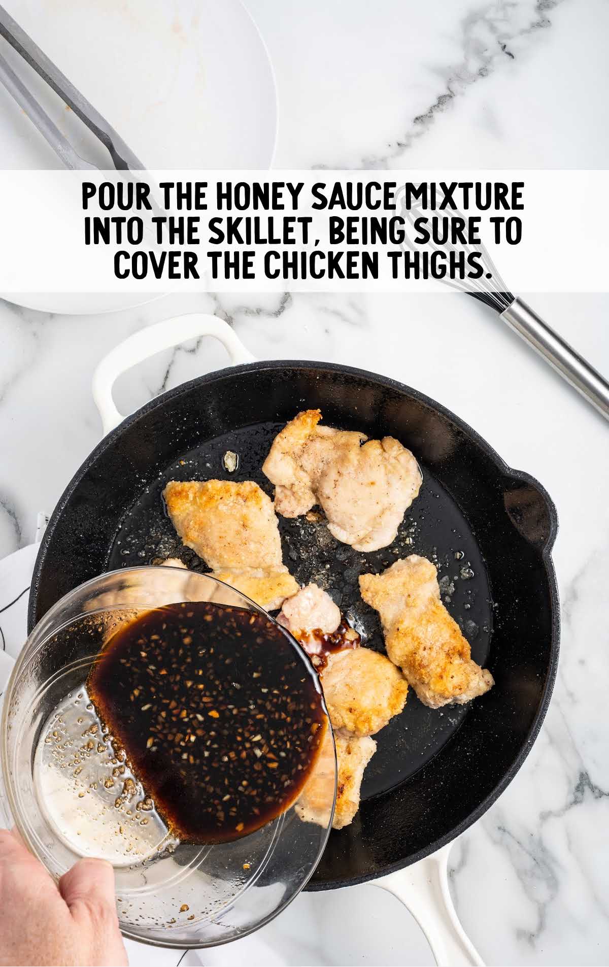 honey sauce mixture poured on top of the chicken thighs in a skillet