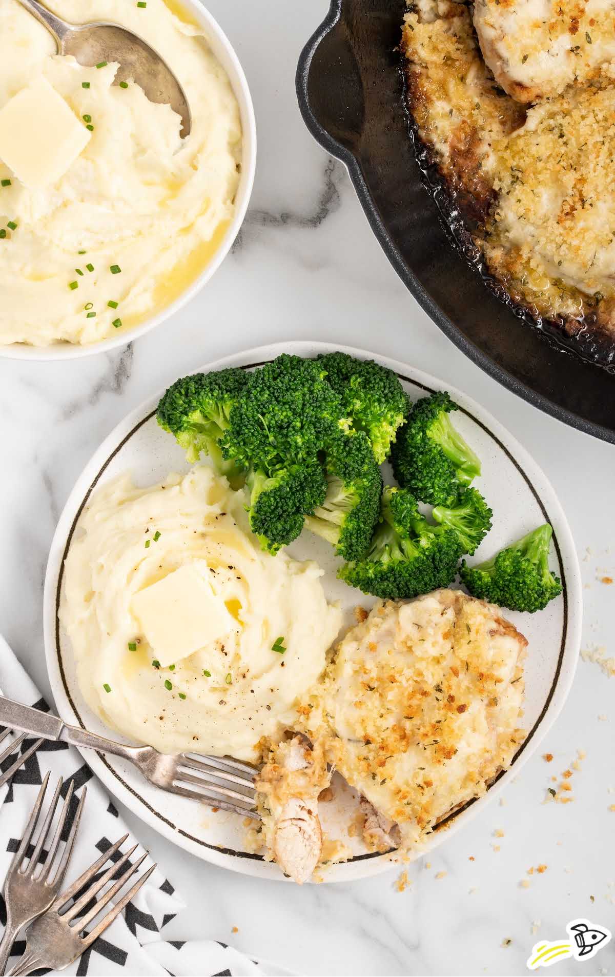 overhead shot of a plate of parmesan crusted chicken served with mashed potatoes and the broccoli