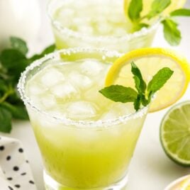 close up shot of a glass of Mint Margarita topped with a slice of lemon and mint