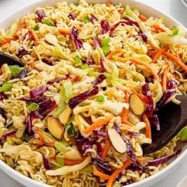 Large bowl of vibrant ramen noodle salad with shredded cabbage, carrots, green onions, and sliced almonds