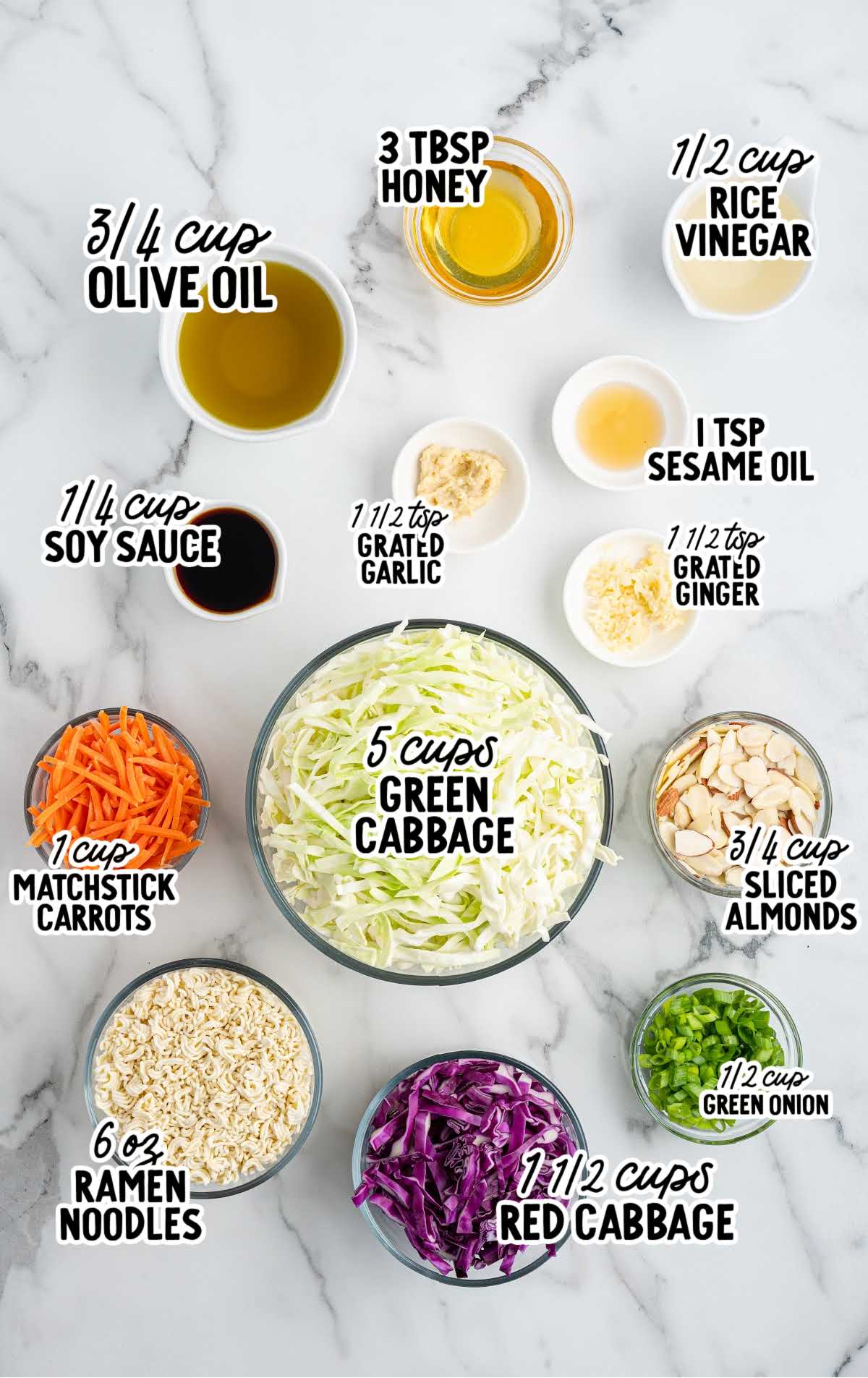 Overhead view of labeled ingredients for ramen noodle salad including cabbage, ramen noodles, soy sauce, vinegar, and almonds
