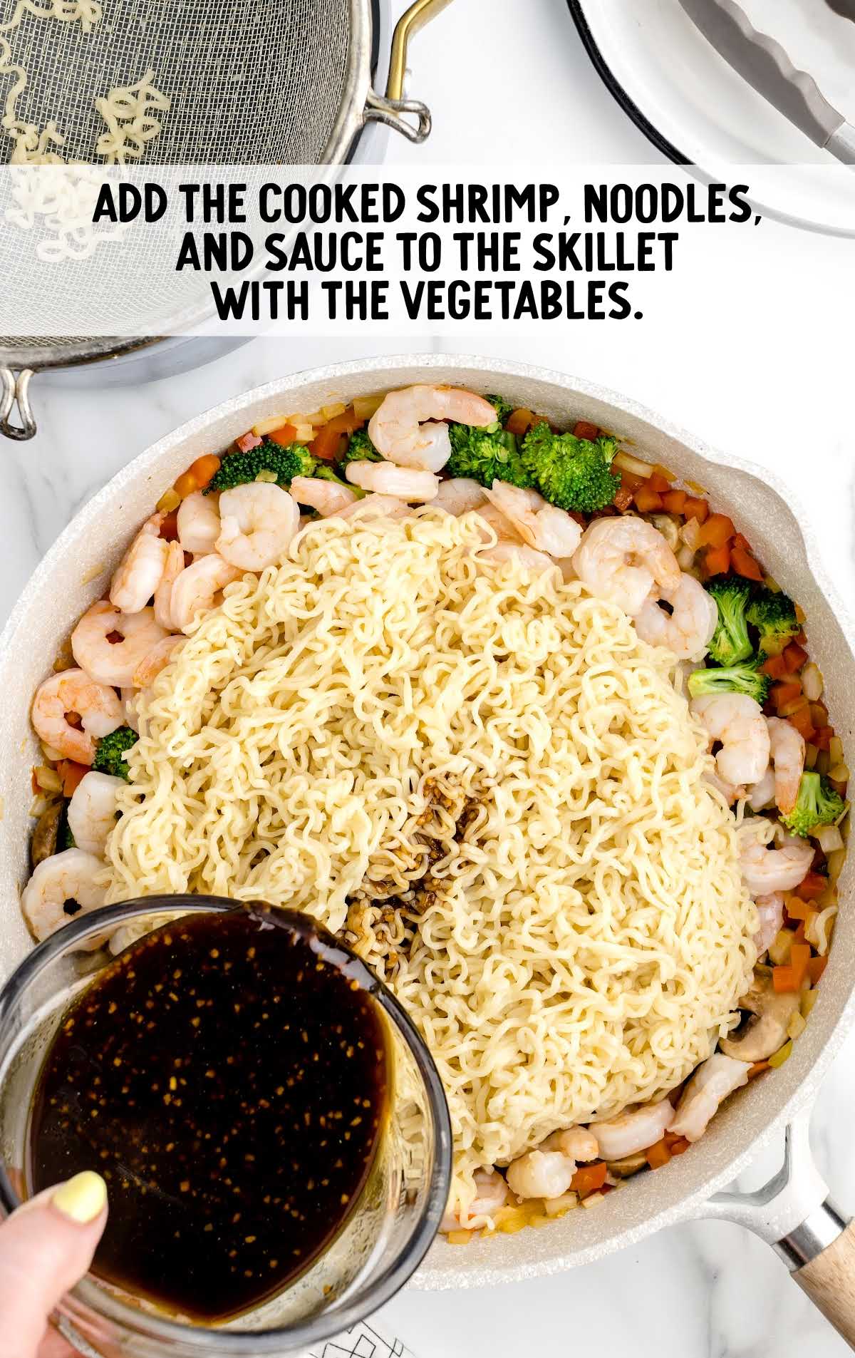shrimp, noodles, and sauce added to the vegetables