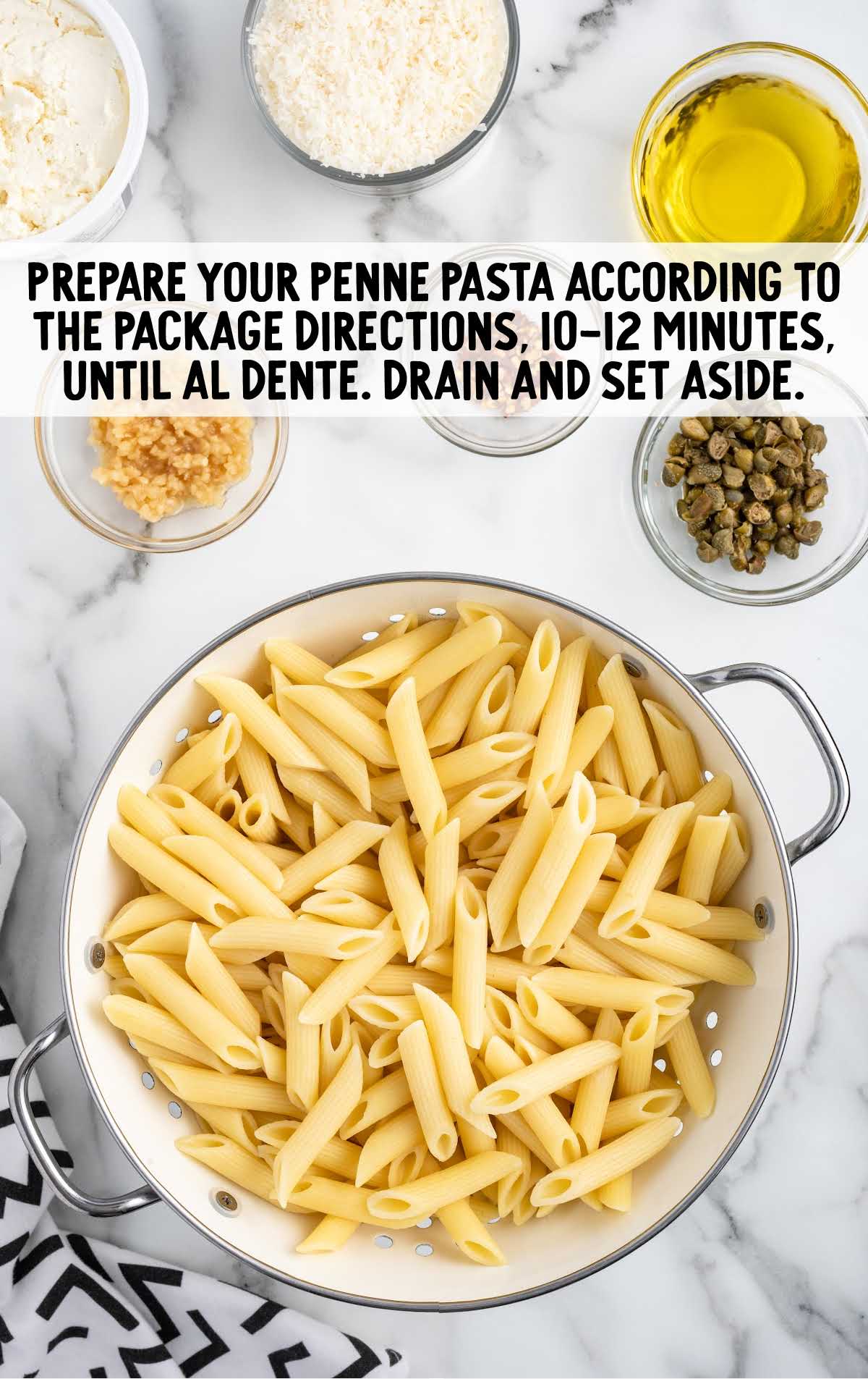 cooked penne pasta in a strainer
