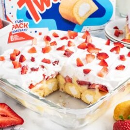close up shot of Twinkie Cake topped with cut up strawberries in a baking dish