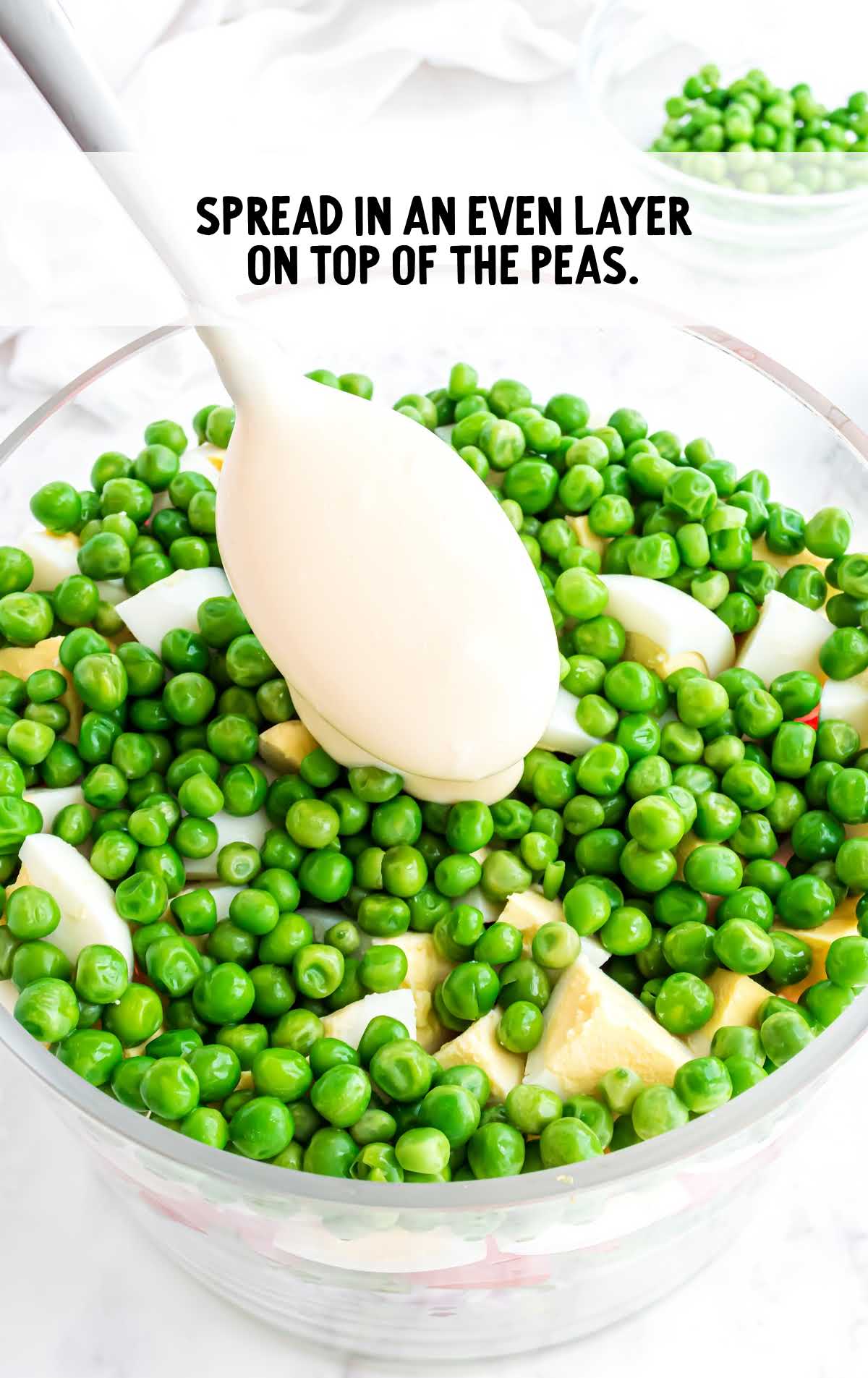 mayonnaise and sugar spread on top of the peas in a big jar