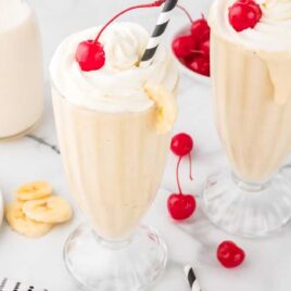 a close up shot of a couple of Banana Milkshake in a tall glass
