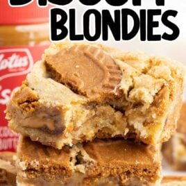 a close up shot of Biscoff Blondies stacked on top of each other with one having a bite taken out of it