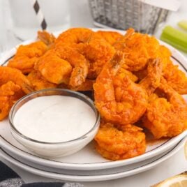 close up shot of a plate of Buffalo Shrimp served with a bowl of ranch