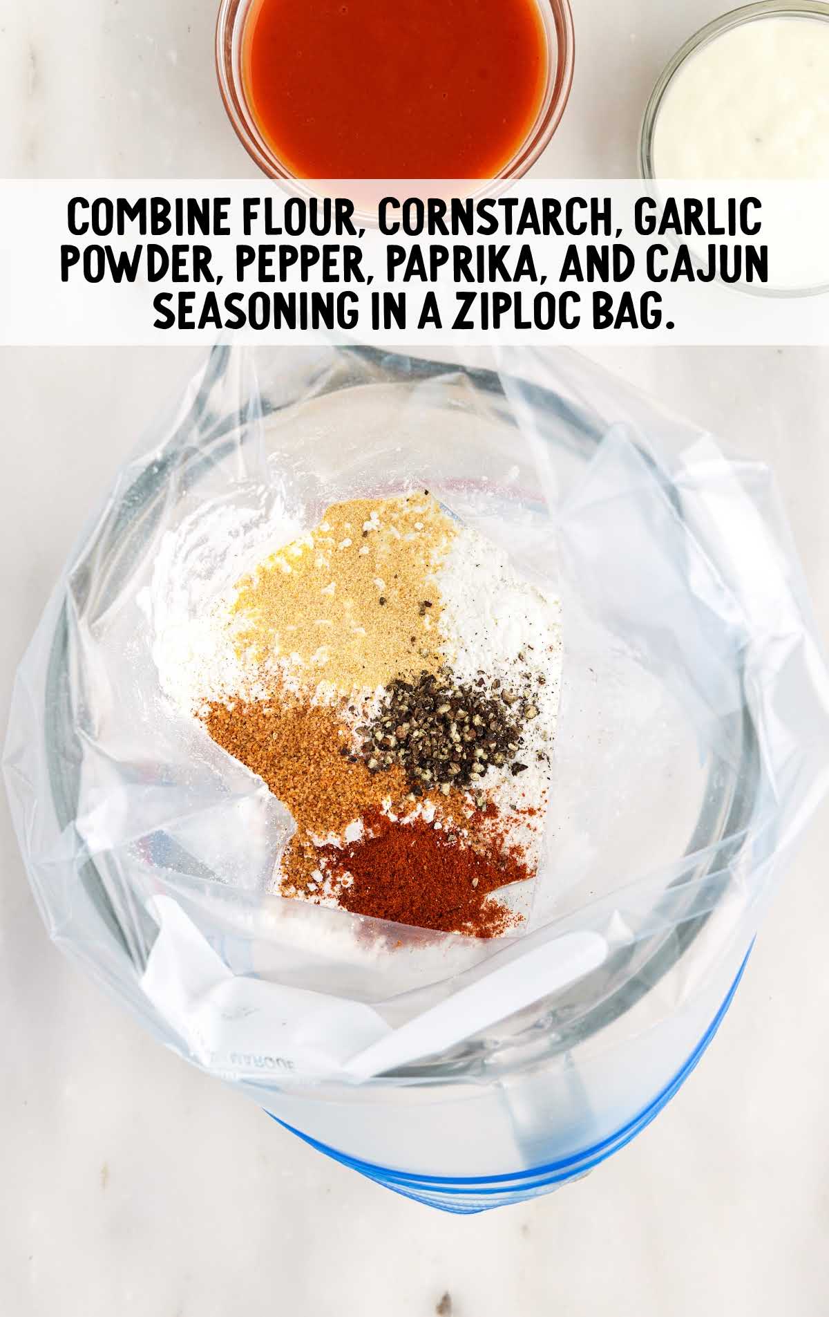 flour, cornstarch, garlic powder, black pepper, paprika, and Cajun seasoning added to a bowl