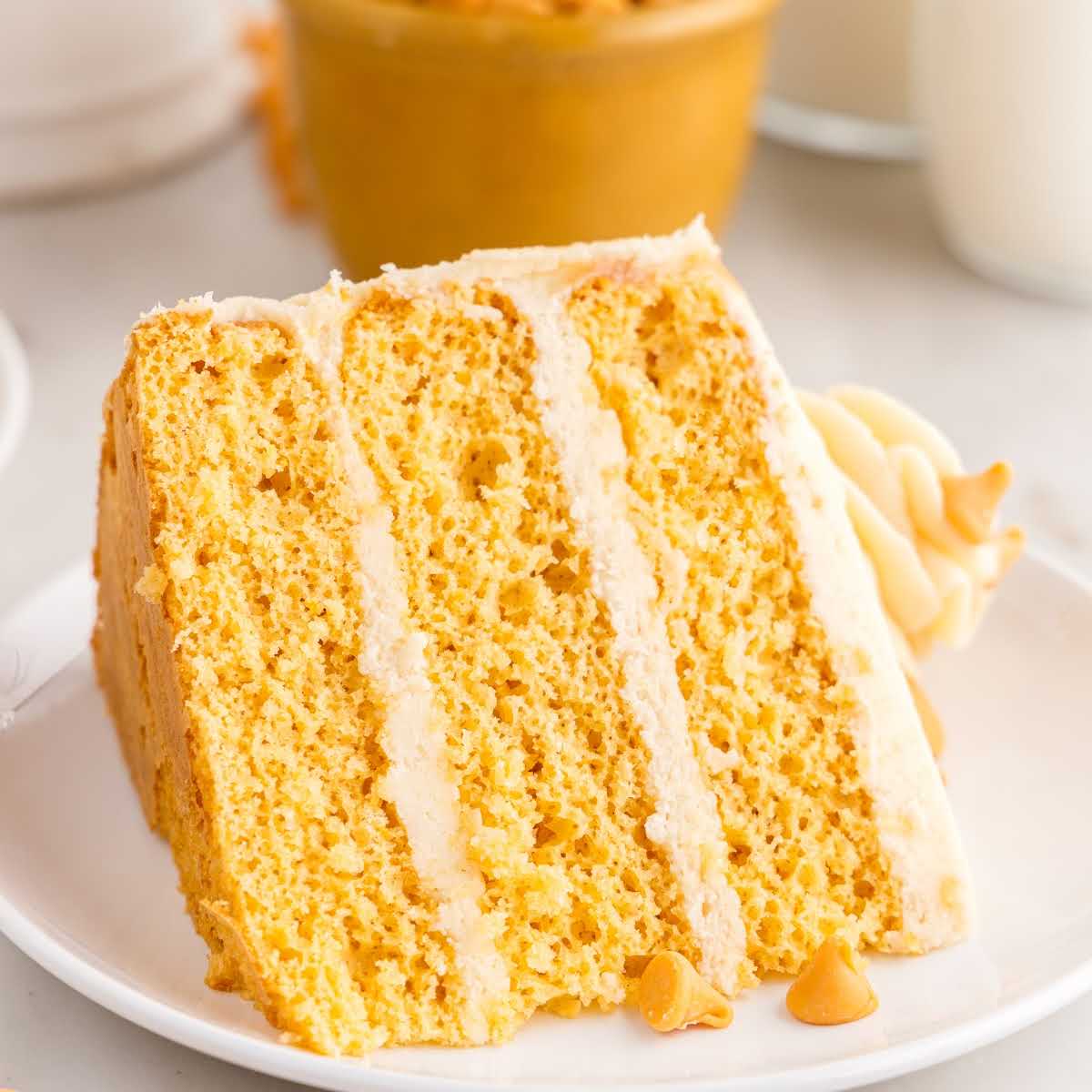 a slice of Butterscotch Cake on a plate topped with whipped cream and butterscotch sauce