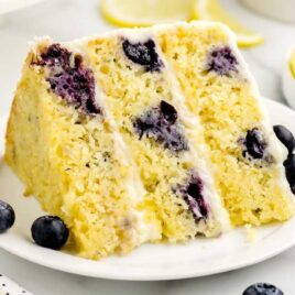 a close up shot of a slice of Lemon Blueberry Cake on a plate