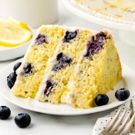a close up shot of a slice of Lemon Blueberry Cake on a plate