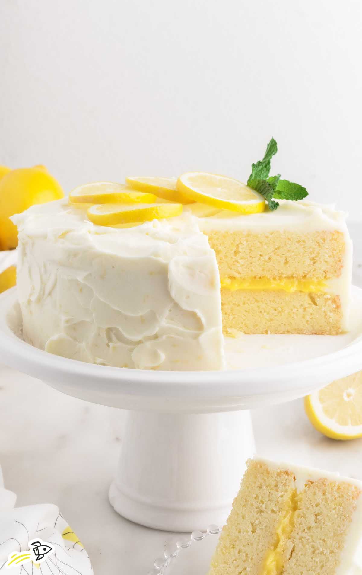 a close up shot of Lemon Curd Cake on a cake stand with a slice taken out