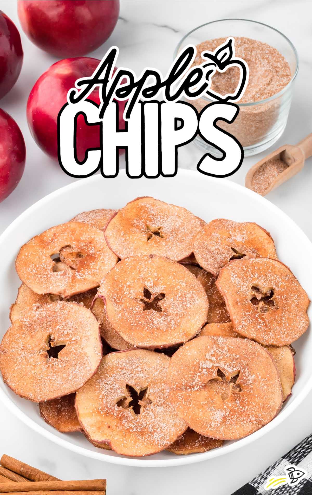 close up shot of a bowl of Apple Chips with apples in the back