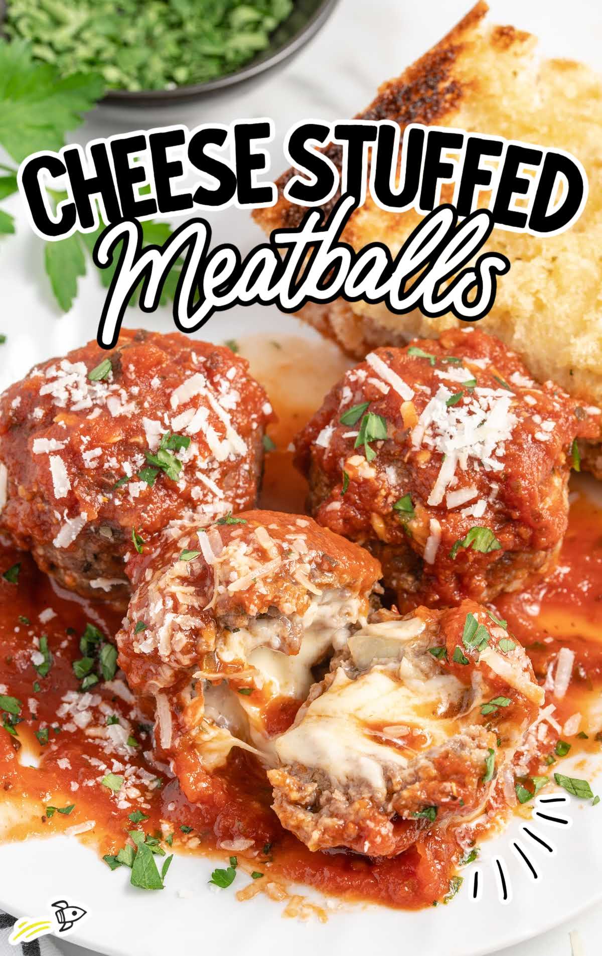 close up shot of Cheese Stuffed Meatballs on a plate with one split in half