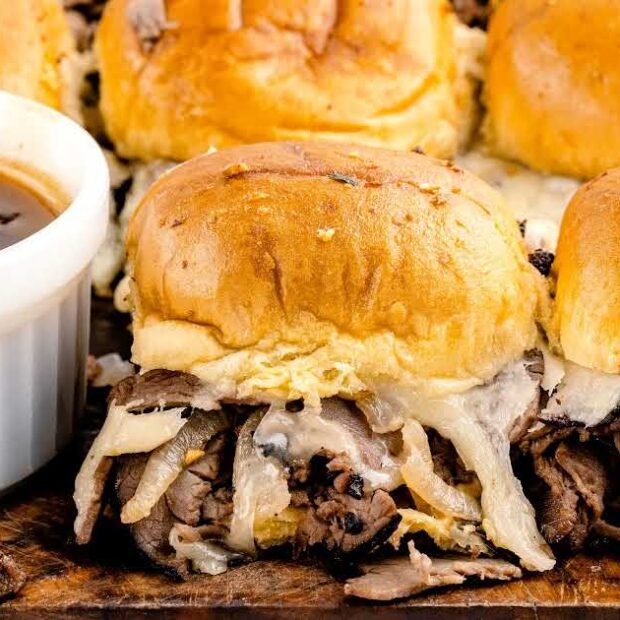 close up shot of French Dip Sliders with a bowl of sauce