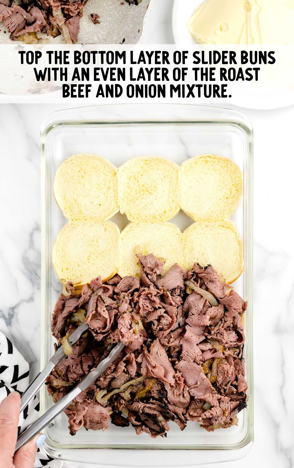 bottom layer of slider buns topped with an even layer of roast beef and onion mixture