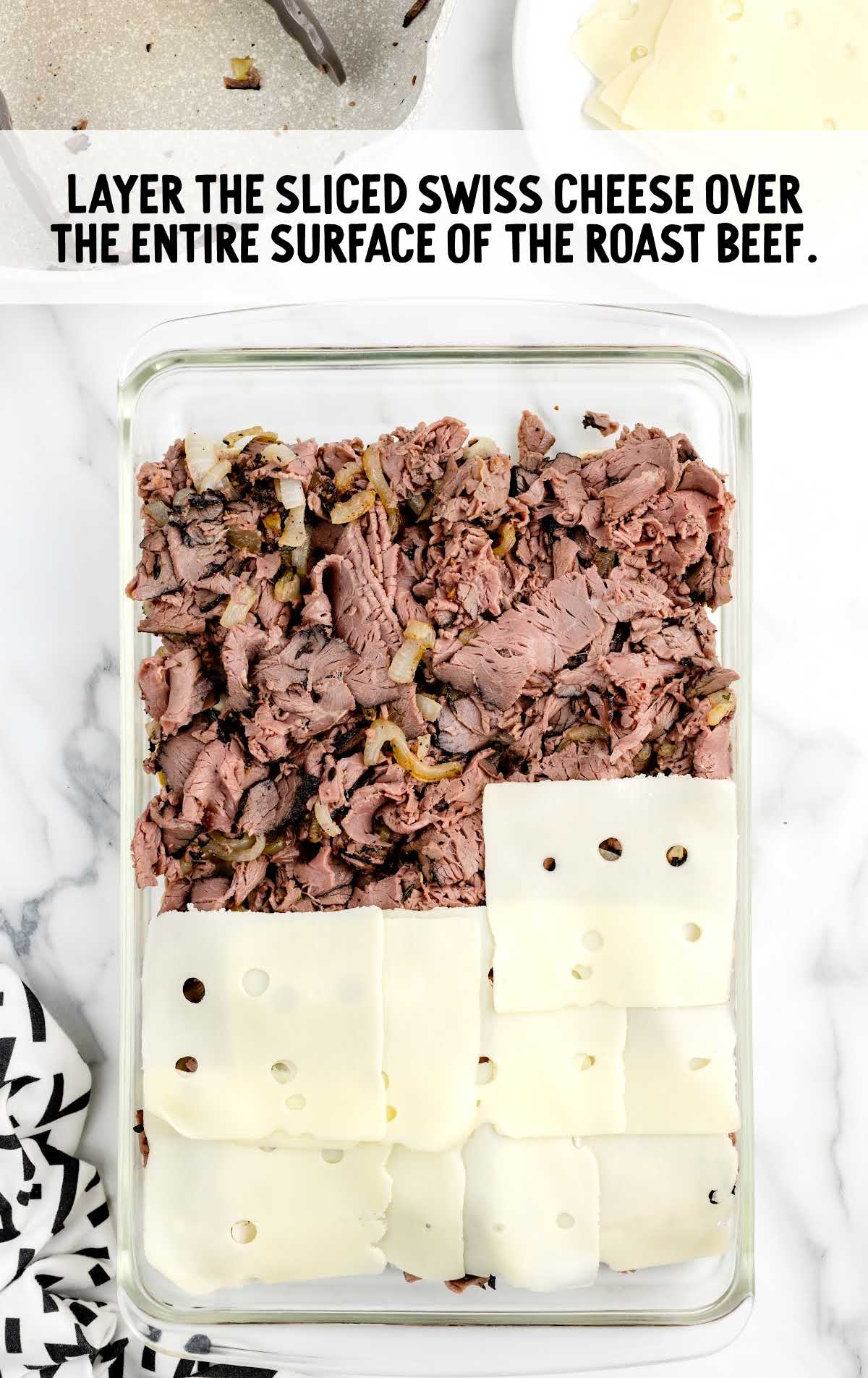 Swiss cheese layered over the entire surface of the roast beef