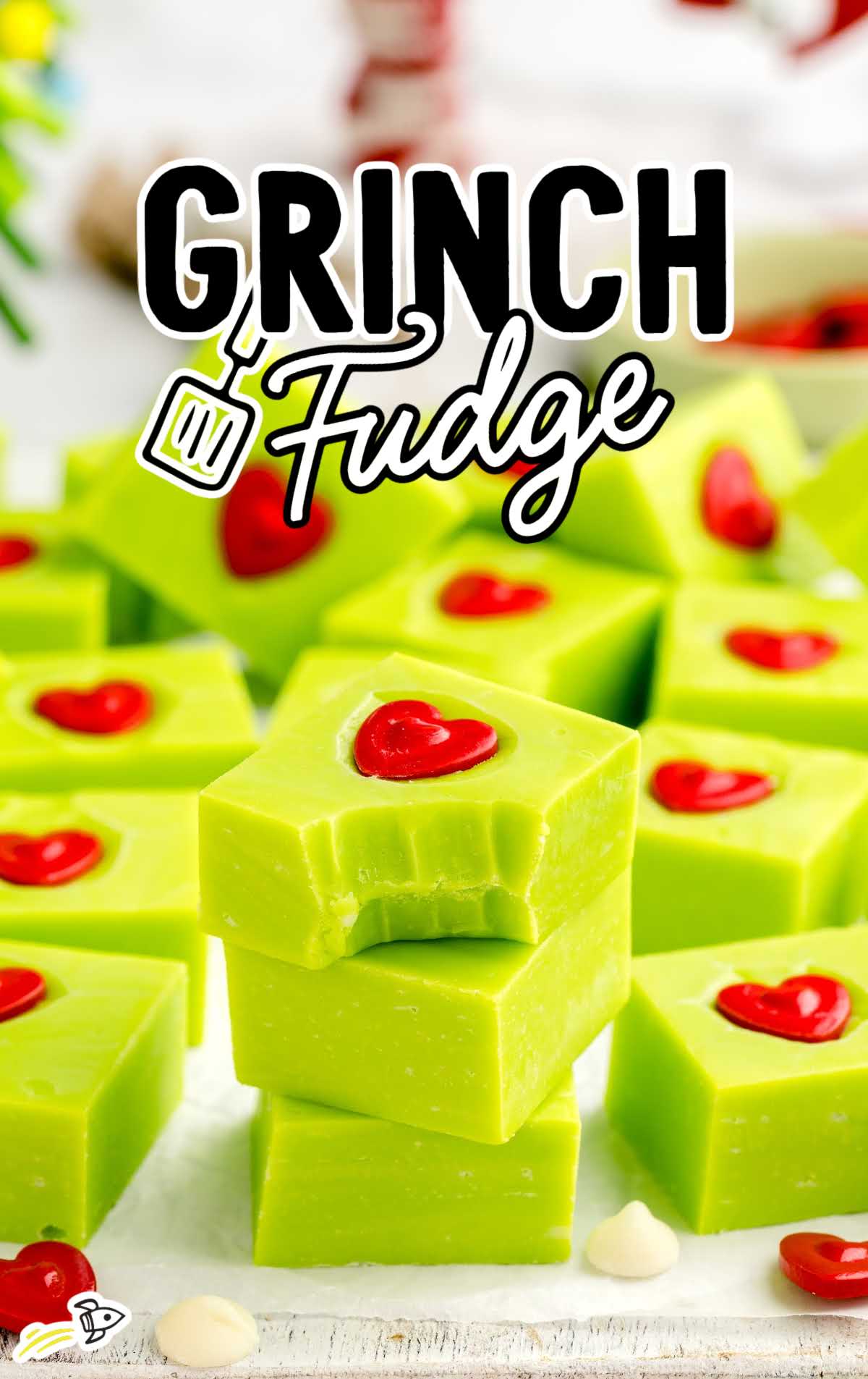 a close up shot of pieces of Grinch Fudge stacked on top of each other with one having a bite taken out of it