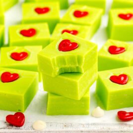 a close up shot of pieces of Grinch Fudge stacked on top of each other with one having a bite taken out of it