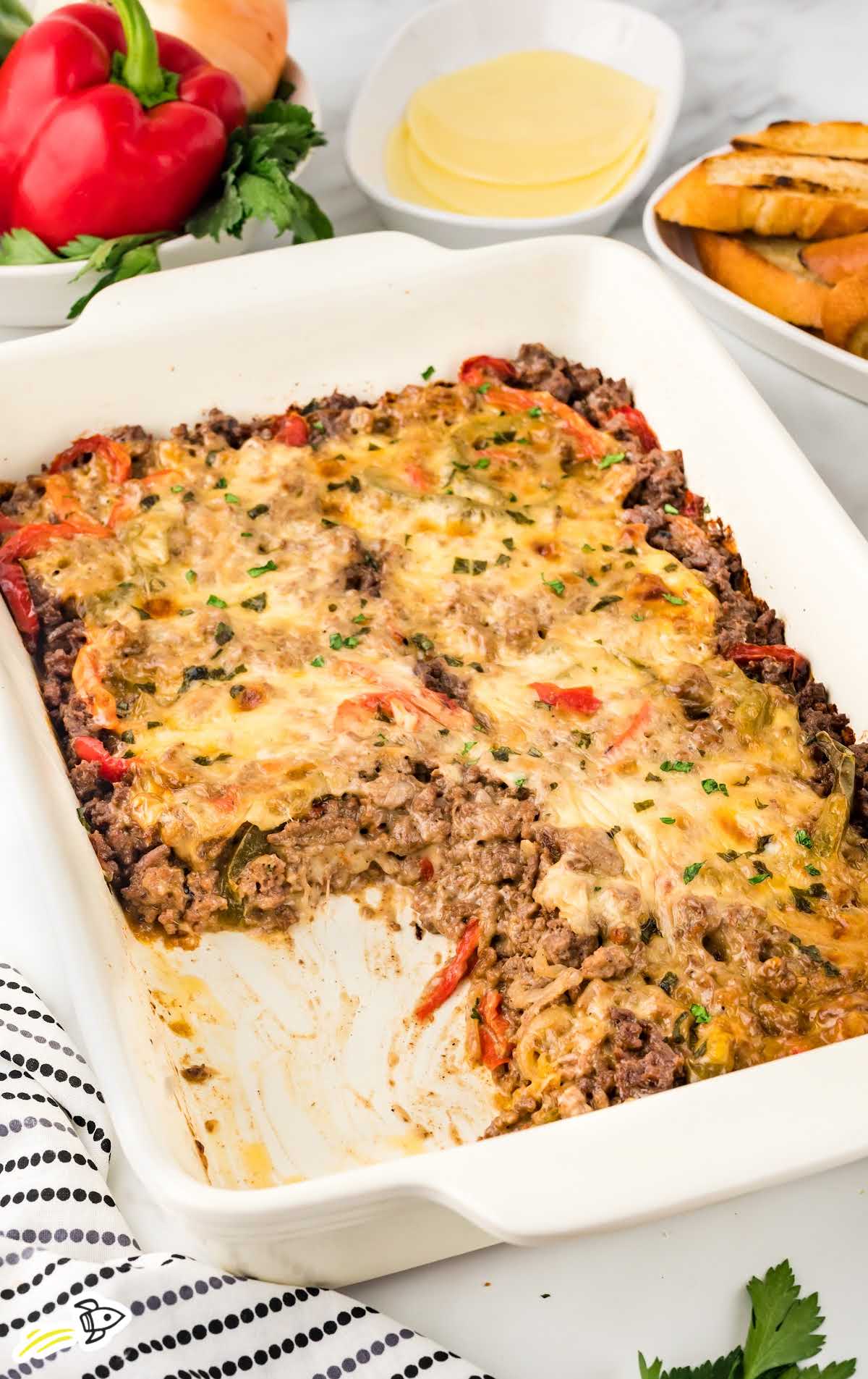 Philly Cheesesteak Casserole garnished with parsley in a baking dish