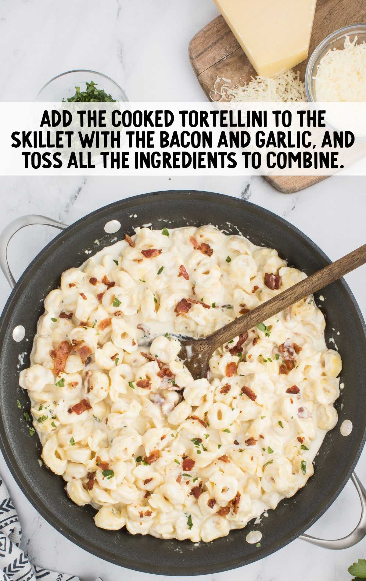 cooked tortellini added to the skillet with the bacon and garlic