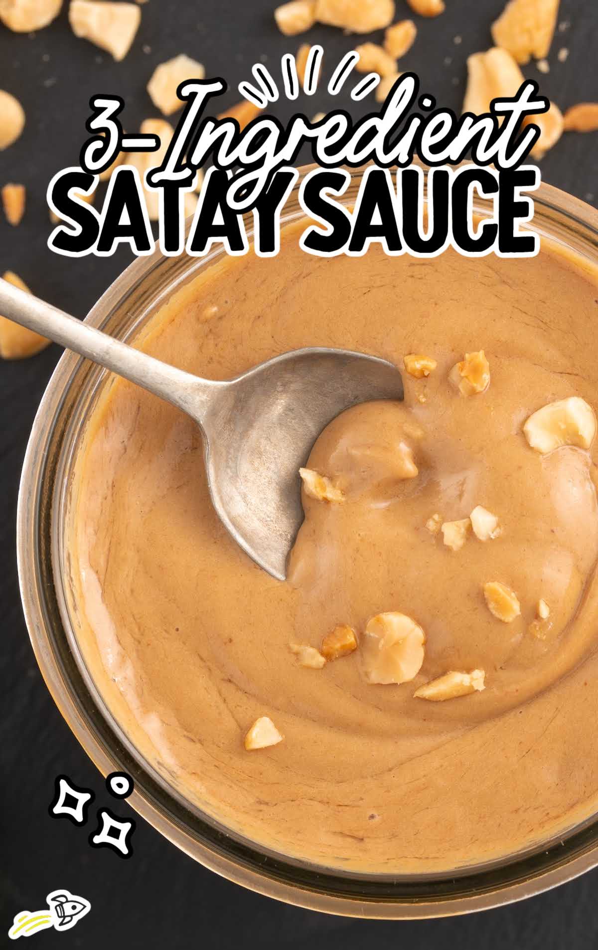 overhead shot of 3 Ingredient Satay Sauce in a jar with a spoon grabbing a piece