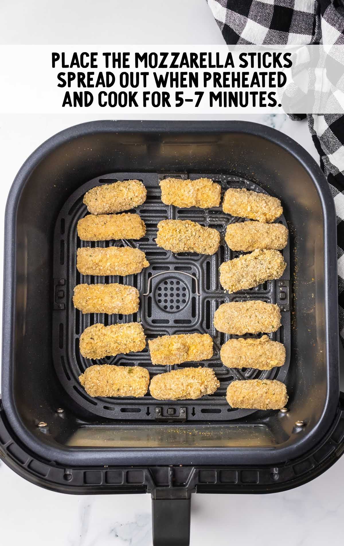 Mozzarella sticks spread out on the air fryer and cooked