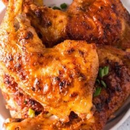 overhead shot of Baked Chicken Legs garnished with green onions on a plate