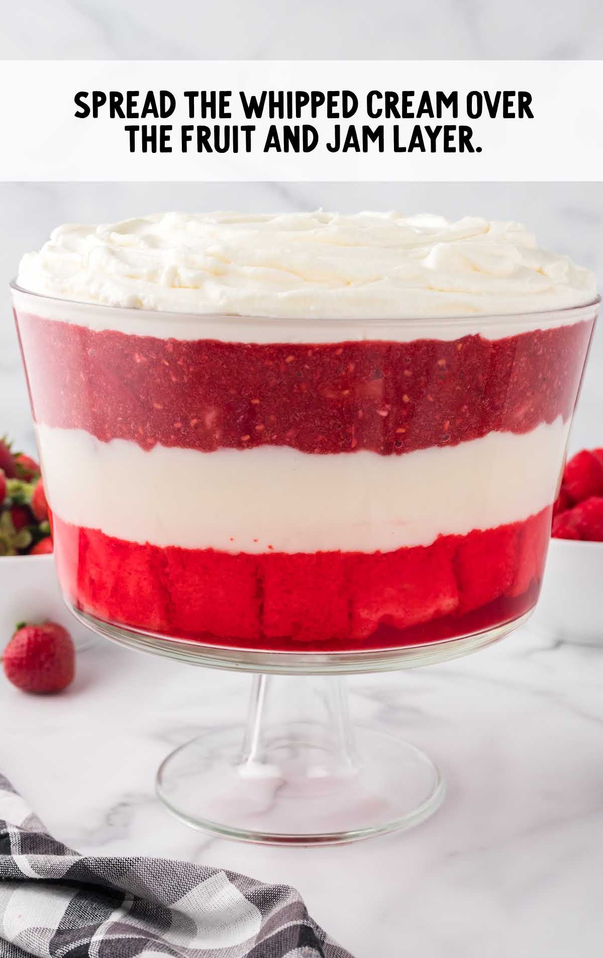 whipped cream spread over the fruit and jam layer