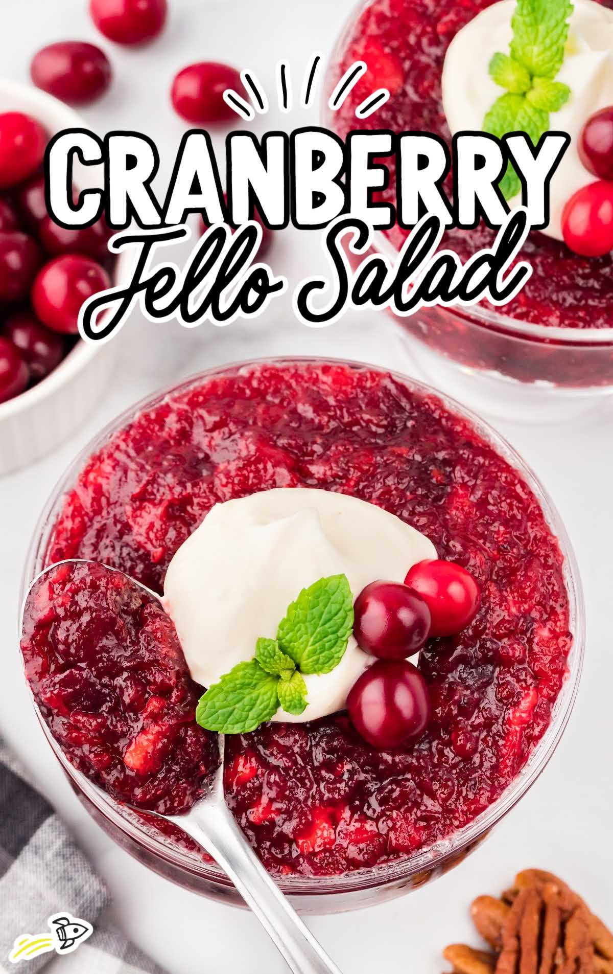 overhead shot of Cranberry Jello Salad in a bowl with a spoon grab bing a piece
