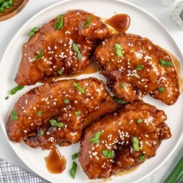 a plate of Honey Garlic Chicken Breasts topped with sesame seeds and green onions